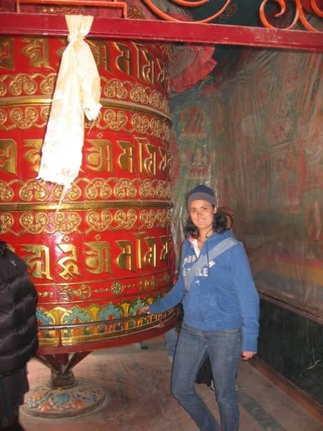 Juliana beside a prayer wheel in Nepal
